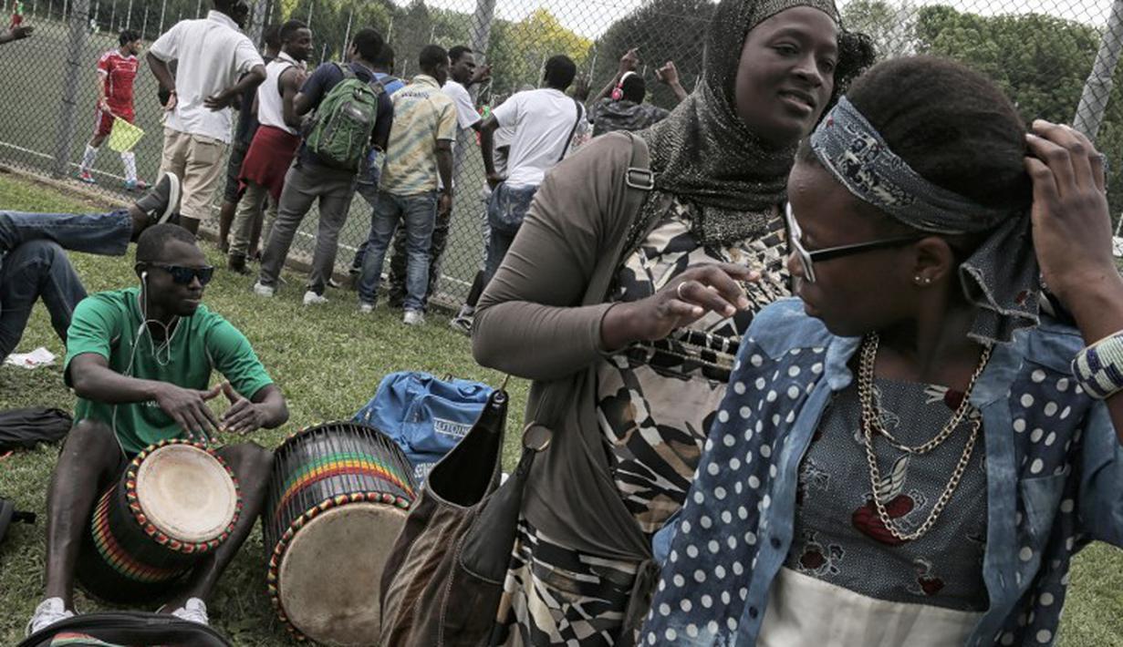 Suporter Mali  saat bertanding melawan Guinea dalam turnamen sepak bola untuk kaum migran dan orang asing bertajuk "Balon Mundial" yang dihelat 6 Juni-5 Juli 2015 di Turin, Italia. (AFP PHOTO/MARCO BERTORELLO)