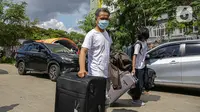 Warga negara Indonesia (WNI) membawa koper mereka usai menjalani isolasi di RSDC Wisma Atlet Pademangan, Jakarta, Selasa (15/6/2021). Pemerintah mewajibkan WNI yang baru tiba di Indonesia untuk melakukan isolasi selama lima hari guna menghindari penularan COVID-19. (Liputan6.com/Faizal Fanani)