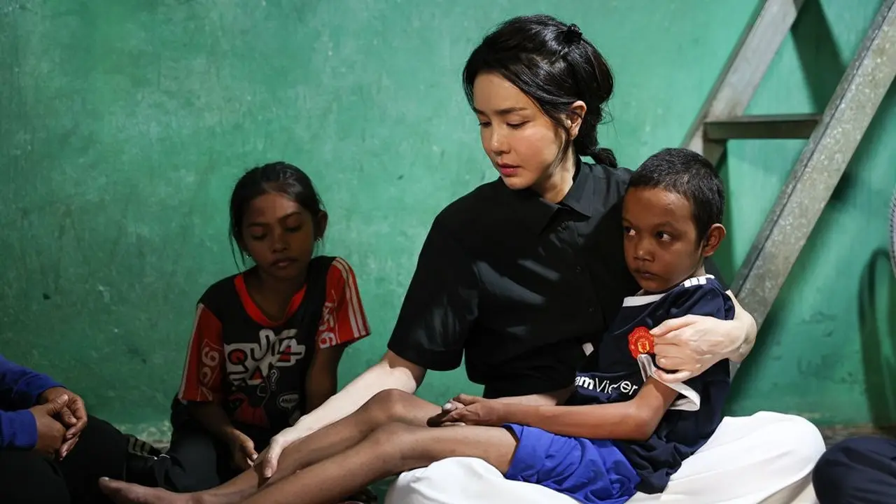 Menggunakan Baju Polo Hitam, Beginilah Potret Kim Keon-hee Gendong Anak yang Sakit di Kamboja