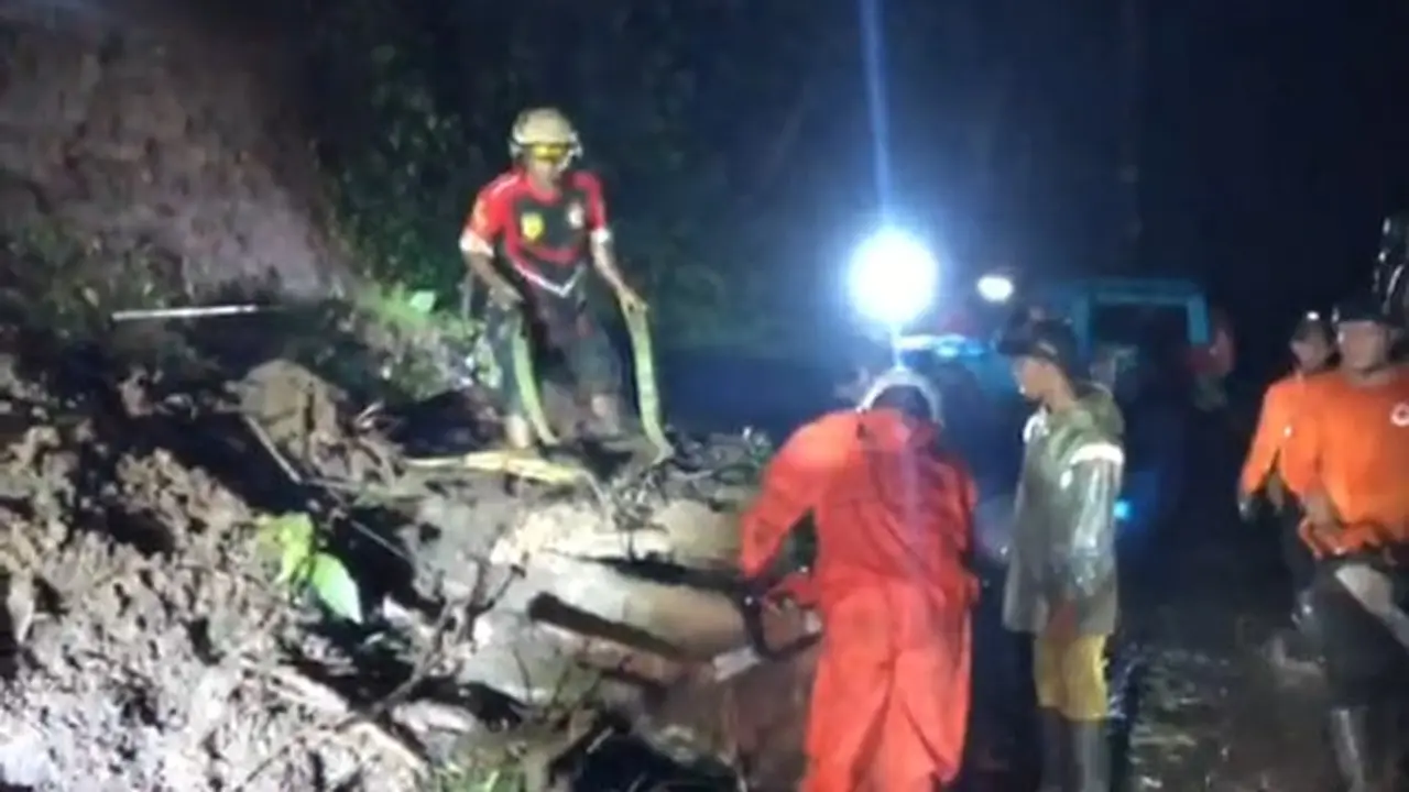Petugas melakukan pembersihan longsoran tebing di kawasan jalur Gumitir yang menutup badan jalan penghubung Kabupaten Banyuwangi - Jember. (Istimewa)