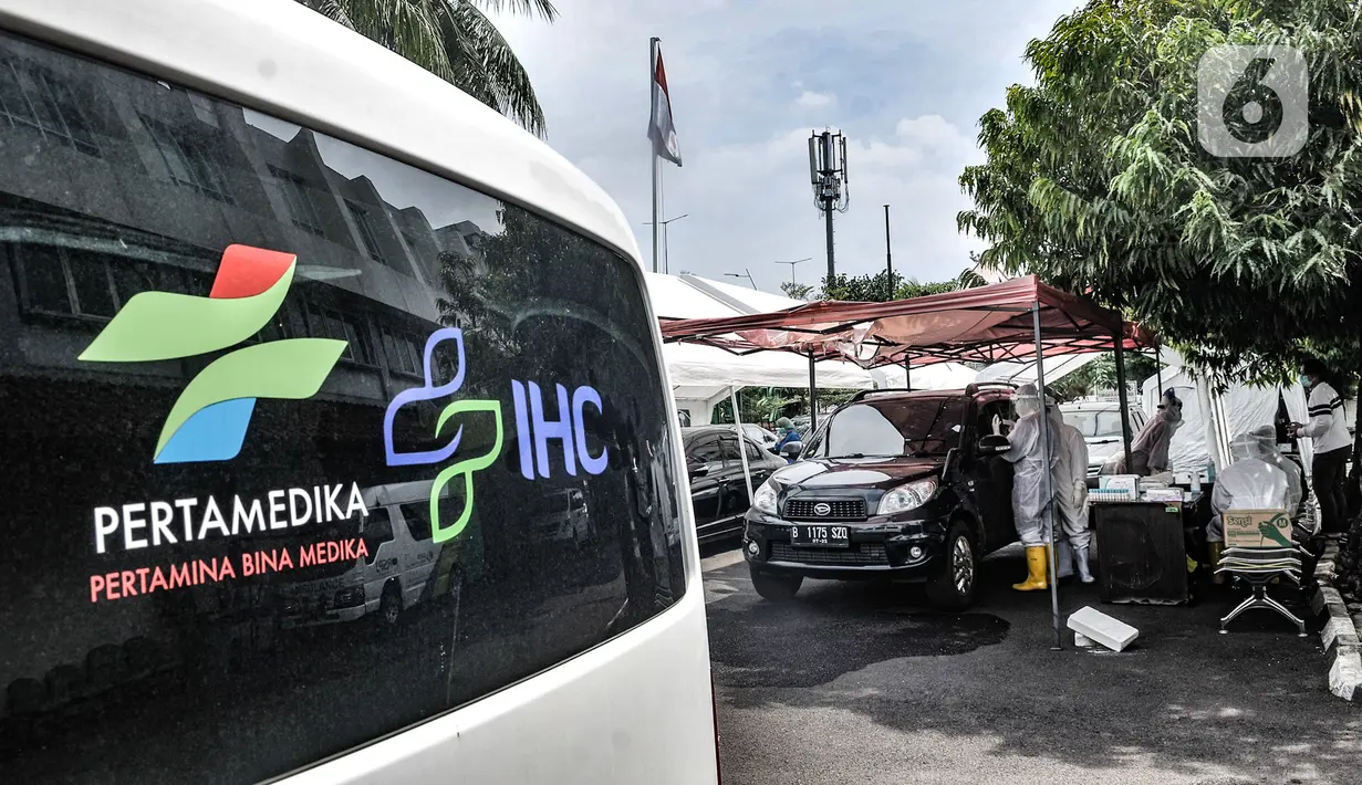 Petugas kesehatan melakukan tes usap PCR drive thru kepada pengguna kendaraan di halaman Rumah Sakit Pertamina Jakarta (RSPJ), Rabu (6/1/2021). RSPJ menyediakan layanan tes usap PCR mandiri secara drive thru guna melacak sekaligus memutus penyebaran Covid-19. (merdeka.com/Iqbal Nugroho)