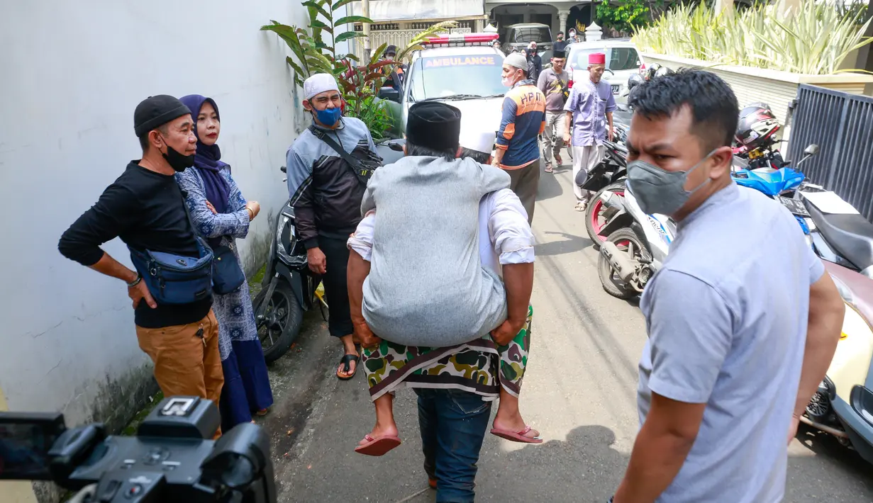 Pria berusia 49 tahun itu tampak digendong menuju ambulan yang sebelumnya membawa jenazah ibundanya.[Foto: Muhammad Akrom Sukarya/© KapanLagi.com]