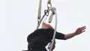Seorang akrobatis udara asal Amerika, Erendira Wallenda bergelantungan pada sebuah helikopter menggunakan giginya, Kamis (15/7). Aksi bergelantungan di atas air terjun Niagara dengan giginya itu berhasil memecahkan rekor dunia. (AP Photo/Bill Wippert)