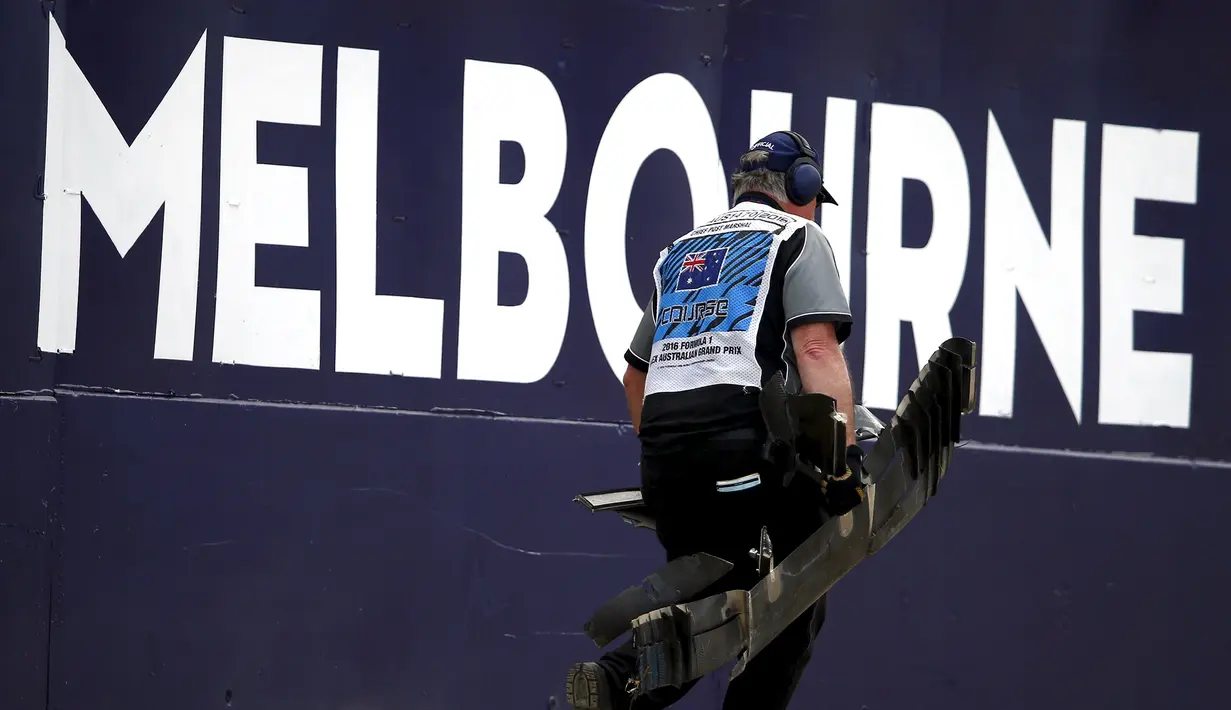 Marshal membawa puing mobil balap yang hancur akibat kecelakaan antara pembalap McLaren Fernando Alonso dan pembalap Haas, Esteban Gutierrez pada pertarungan di lap 17 F1 Grand Prix Australia di Melbourne,  Minggu (20/3). (REUTERS/Joe Castro)