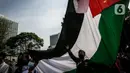 Massa yang tergabung dalam Aliansi Pemuda Indonesia untuk Palestina mengibarkan bendera Palestina saat aksi solidaritas di depan Kedutaan Besar Amerika Serikat, Jakarta, Selasa (18/5/2021). Massa mengajak masyarakat Indonesia untuk terus mendukung dan membantu Palestina. (Liputan6.com/Faizal Fanani)