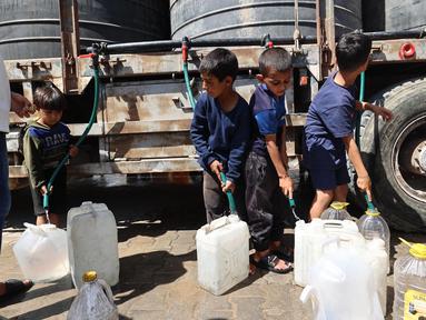 Anak-anak Palestina mengisi wadah mereka dengan air di kamp Nuseirat untuk para pengungsi di Jalur Gaza tengah pada 24 Mei 2025. (Eyad BABA/AFP)
