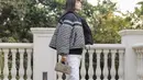 Aktris asal Hong Kong, Elva Ni tampil modis dengan padu padan Reversible Cropped Down Jacket, long pants puth, sepatu boots, dan tas Dior Lady D-Joy warna hazelnut. [Dior].