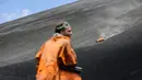 Seorang wisatawan memperhatikan rekannya yang bermain sandboarding atau berseluncur pasir menuruni gunung berapi Cerro Negro di Leon, Nikaragua, 24 September 2016. Gunung Cerro Negro salah satu gunung api yang masih aktif di Nikaragua. (INTI Ocon/AFP)