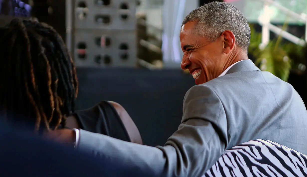 Mantan Presiden AS, Barack Obama berbincang dengan adik tirinya, Auma saat pulang kampung ke tanah kelahiran ayahnya di Kogelo, Kenya, Senin (16/7). Ini adalah kunjungan pertama Obama ke Kenya usai tidak lagi menjabat presiden. (AP/Brian Inganga)