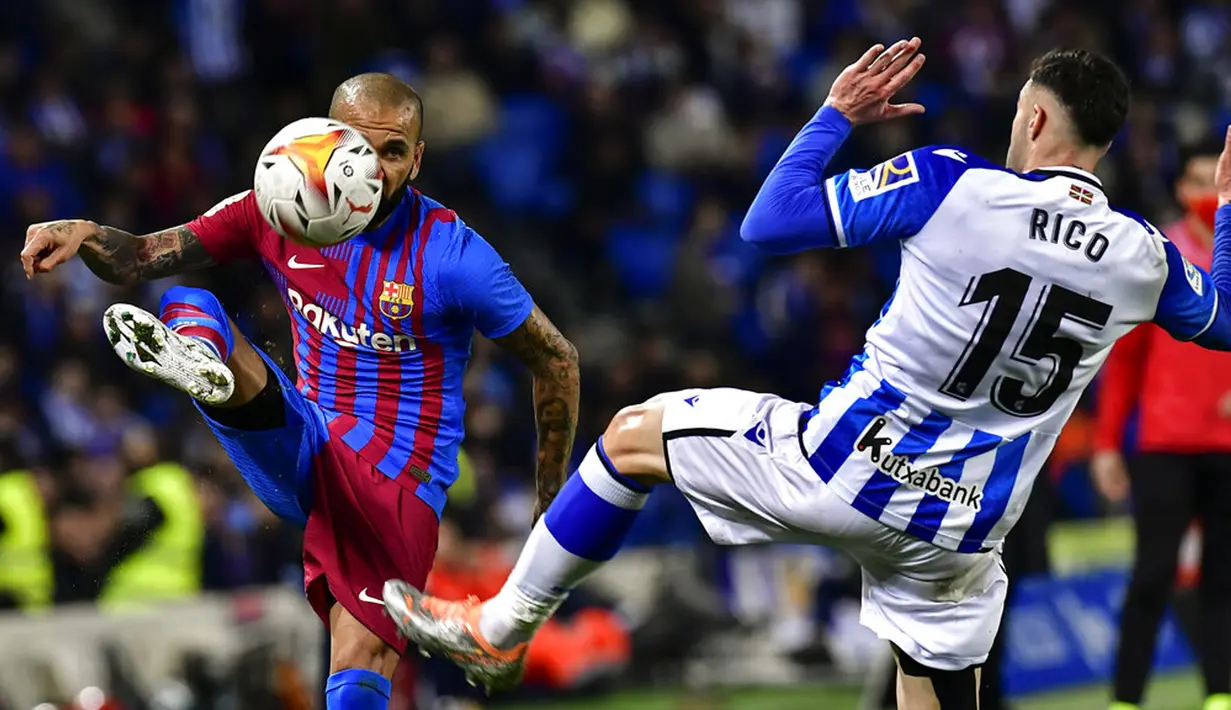 <p>Pemain Barcelona Dani Alves (kiri) berebut bola dengan pemain Real Sociedad Diego Rico pada pertandingan Liga Spanyol di Reale Arena Stadium, San Sebastian, Spanyol, 21 April 2022. Barcelona menang 1-0. (AP Photo/Alvaro Barrientos)</p>