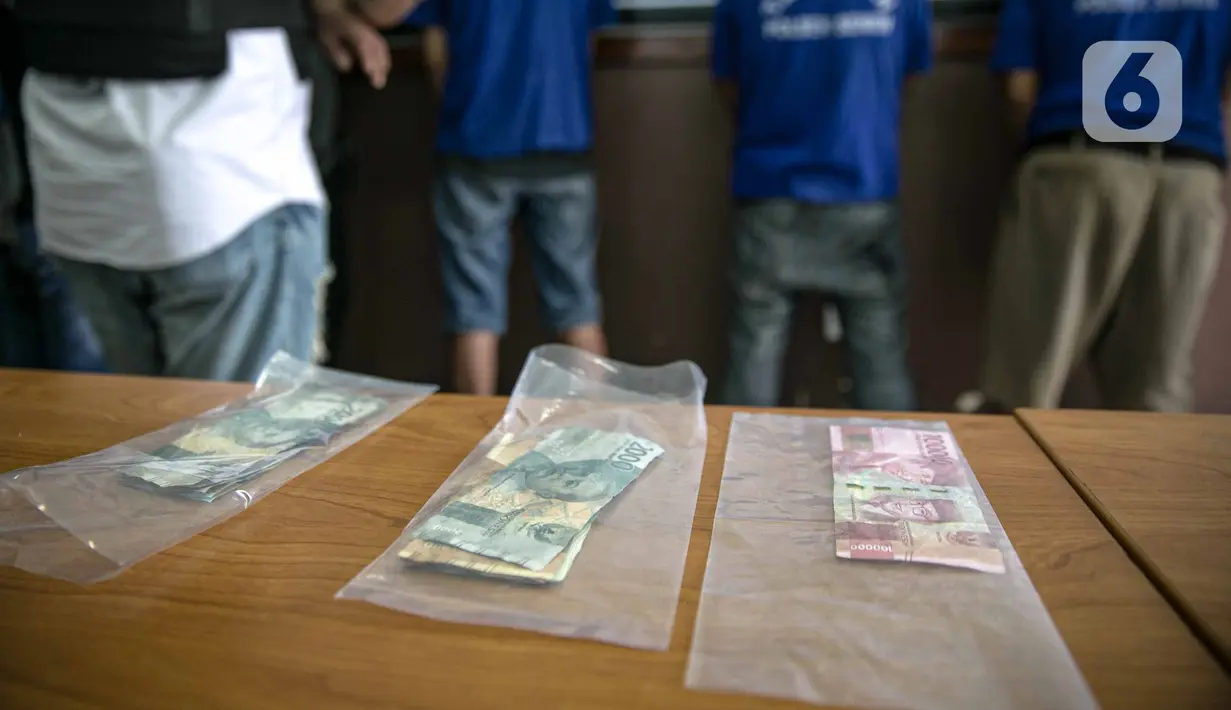 Barang bukti kasus pemalsuan surat hasil rapid test COVID-19 diperlihatkan dalam rilis di Mapolres Jakarta Pusat, Minggu (20/12/2020). Polisi menangkap tiga tersangka beserta bukti uang hasil transaksi pemalsuan surat hasil rapid test COVID-19. (Liputan6.com/Faizal Fanani)