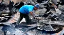 Seorang lelaki terlihat berusaha mencari harta benda yang masih bisa diselamatkan dari kebakaran yang melanda tempat tinggalnya. (Liputan6.com/Andrian M Tunay)