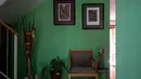 Sebuah kursi, tanaman, lukisan, dan sosok Catrina, semua milik Hebert Axel Gonzalez, sutradara teater yang meninggal karena COVID-19 pada April, kini menghiasi pintu masuk rumah rekannya Carlos Corro di Tijuana, Negara Bagian Baja California, Meksiko, 23 Juni 2020. (Guillermo ARIAS/AFP)