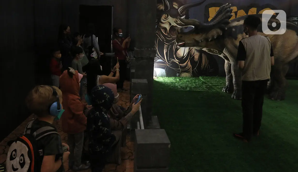 Pengunjung menyaksikan replika hewan prasejarah dalam wahana Dino Factory by Dino Island di Mal Kota Kasablanka, Jakarta, Jumat (17/12/2021). Wahana juga menjadi sarana edukasi pengetahuan tentang hewan-hewan prasejarah kepada para pengunjung. (Liputan6.com/Herman Zakharia)