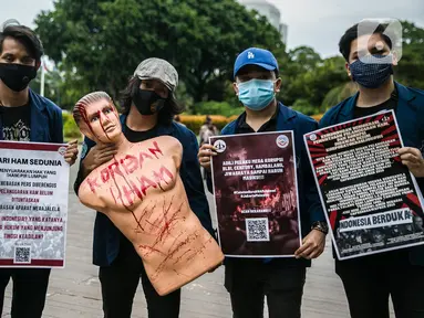 Sejumlah mahasiswa dari Universitas Trisakti menggelar aksi memperingati Hari HAM Internasional di depan Taman Aspirasi, Jakarta, Kamis (10/12/2020). Aksi tersebut menuntut agar pemerintah segera menyelesaikan berbagai permasalahan pelanggaran HAM berat di Indonesia. (Liputan6.com/Faizal Fanani)