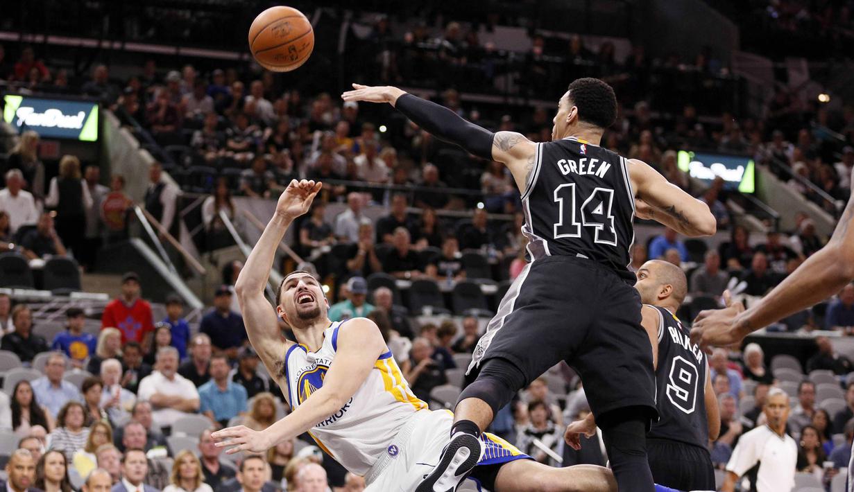 Pemain Golden State Warriors, Klay Thompson (kiri), melakukan tembakan melewati hadangan pemain San Antonio Spurs, Danny Green (14), pada lanjutan NBA di AT&T Center, San Antonio, AS, (10/4/2016). (Reuters/Soobum Im-USA Today Sports)