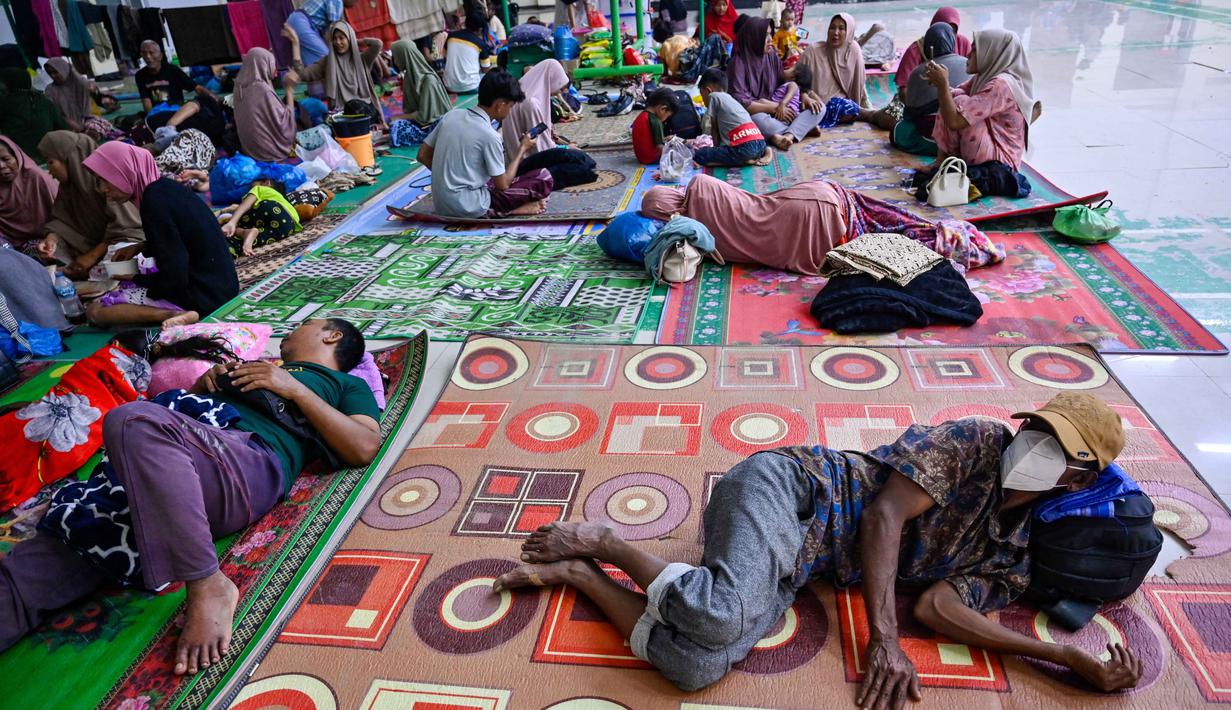 BPBD Pidie Jaya juga mencatat ada sekitar 1.247 rumah terendam, dan 67 lainnya rusak berat akibat longsor. Tampak dalam foto, warga desa terdampak banjir beristirahat di tempat pengungsian setelah banjir bandang melanda Meureudu, Kabupaten Pidie Jaya, Provinsi Aceh, pada 29 November 2025. (CHAIDEER MAHYUDDIN/AFP)