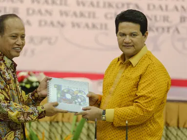 Menristek Dikti, Mohammad Nasir (kiri) bertukar cinderamata dengan Ketua KPU, Husni Kamil di Kantor KPU, Jakarta, Kamis (30/7/2015). Penandatangan terkait kerjasama verifikasi ijazah dalam rangka Pilkada serentak. (Liputan6.com/Faizal Fanani)