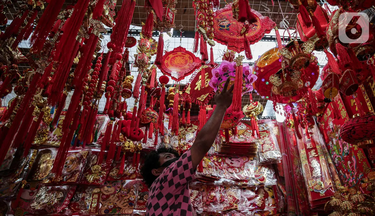 Pedagang merapikan lampu lampion untuk imlek di kawasan Glodok, Jakarta, Sabtu (15/1/2022). Meski Perayaan Tahun Baru Imlek masih beberapa pekan lagi, beragam pernak-pernik Imlek mulai banyak dijajakan di kawasan Pecinan Glodok. (Liputan6.com/Faizal Fanani)