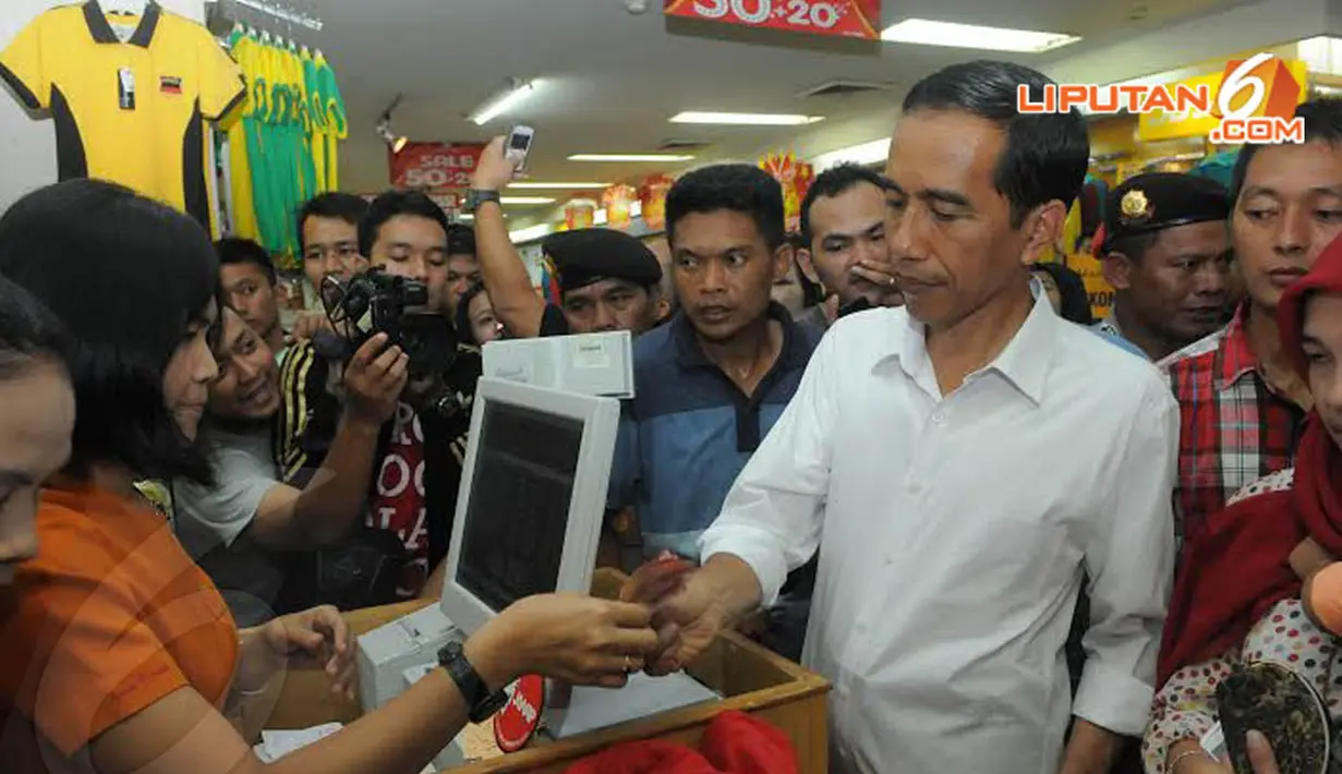  Jokowi pun membayar atas sejumlah barang yang telah dibeli. Aktifitas belanja menjadi salah satu kegiatan yang dilakukan Jokowi di setiap kampanye (Liputan6.com/Herman Zakharia)