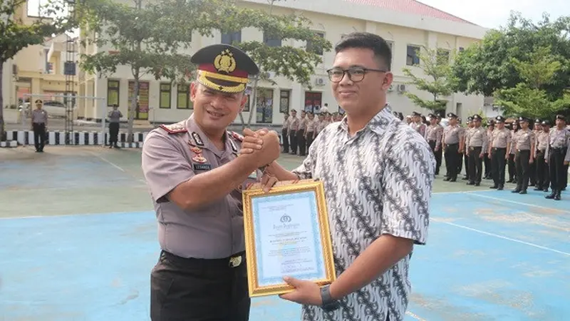 Kapolres Karanganyar, AKBP Leganek Mawardi, (kiri), menyerahkan penghargaan kepada warga Desa Ngringo, Kecamatan Jaten, Muhammad Syahrial Muchtar, (kanan), di Mapolres Karanganyar