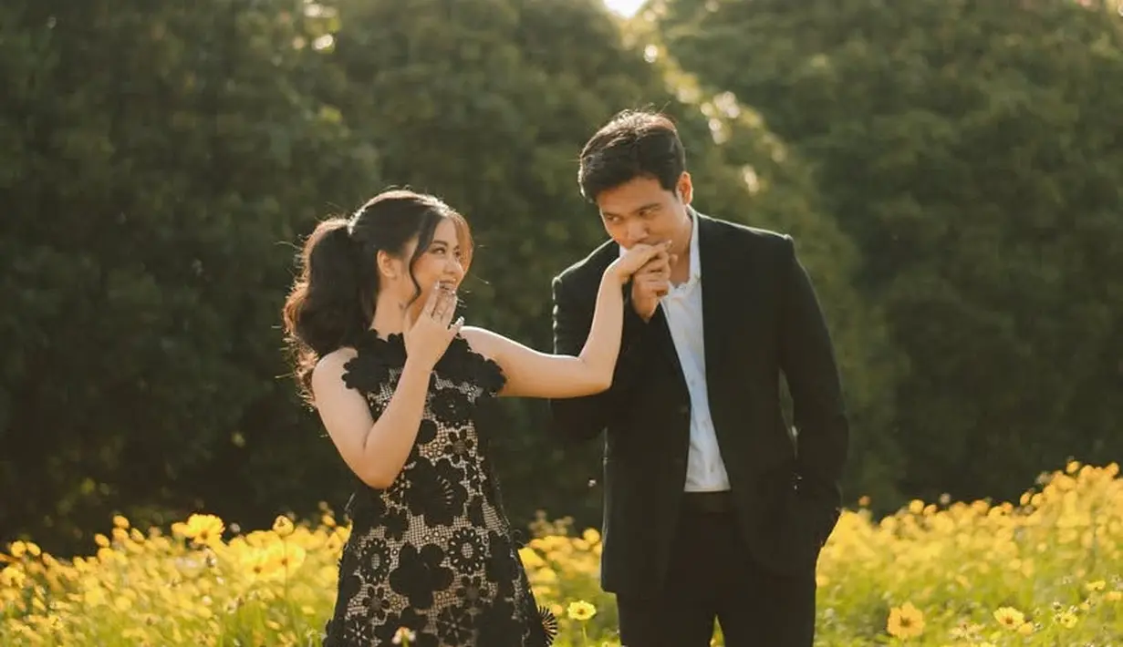 Frans dan Indah tampak memilih konsep nature pada foto prewedding mereka. Keduanya kompak mengenakan pakaian hitam, Frans mengenakan setelan jas hitam senada dengan celananya. [@fransfaisal_]