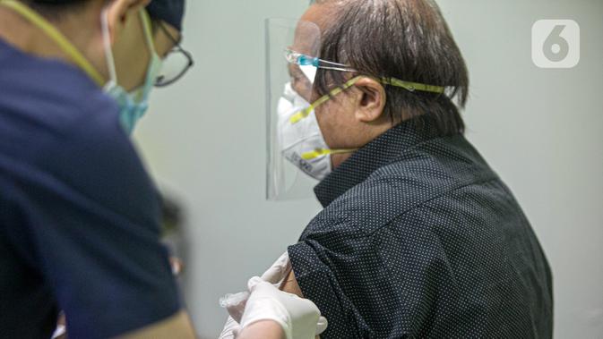 Tenaga kesehatan disuntik vaksin COVID-19 produksi Sinovac oleh vaksinator saat kegiatan vaksinasi di RSCM di Jakarta, Senin (8/2/2021). Kementerian Kesehatan secara resmi memulai vaksinasi tenaga kesehatan di atas 60 tahun pada hari ini. (Liputan6.com/Faizal Fanani)