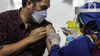 Petugas medis menyuntikkan vaksin COVID-19 kepada pelaku sektor jasa keuangan di Lapangan Tennis Indoor Senayan, Jakarta, Rabu (16/6/2021). Sebanyak 100 ribu dosis vaksin disediakan untuk pelaku sektor jasa keuangan. (Liputan6.com/Faizal Fanani)