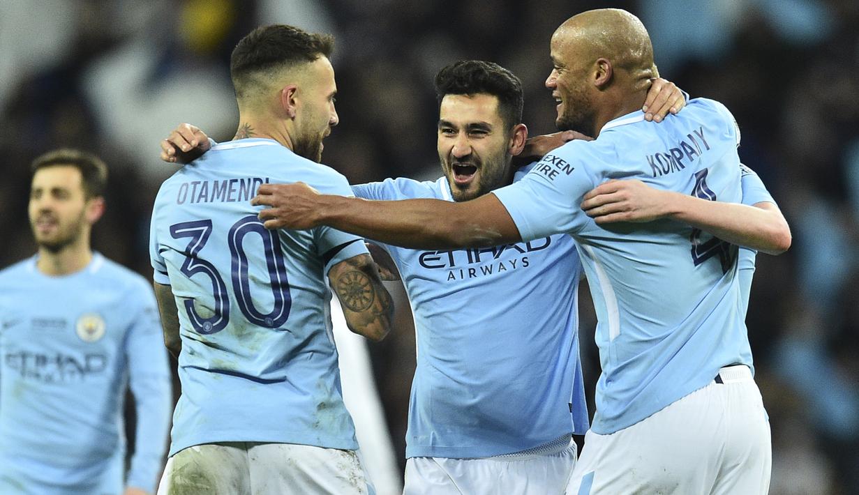 Gelandang Manchester City, Ilkay Gundogan, bersama rekan-rekannya merayakan gelar juara Piala Liga setelah mengalahkan Arsenal di Stadion Wembley, London, Minggu (25/2/2018). City menang 3-0 atas Arsenal. (AFP/Glyn Kirk)