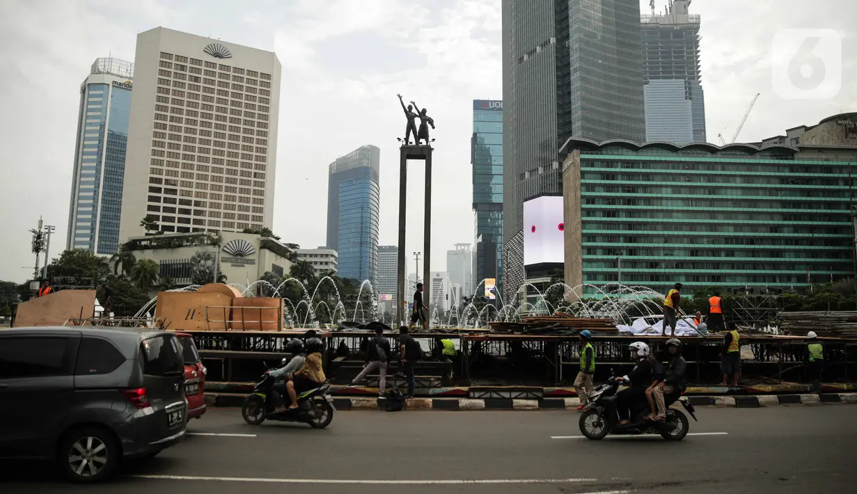 Kendaraan melintas dekat pembuatan panggung untuk acara malam tahun baru di sekitar kawasan Bundaran HI, Jakarta, Rabu (25/12/2019). Merayakan pergantian tahun, Pemprov DKI Jakarta menggelar sejumlah acara di sejumlah titik sepanjang Jalan Sudirman-MH Thamrin. (Liputan6.com/Faizal Fanani)
