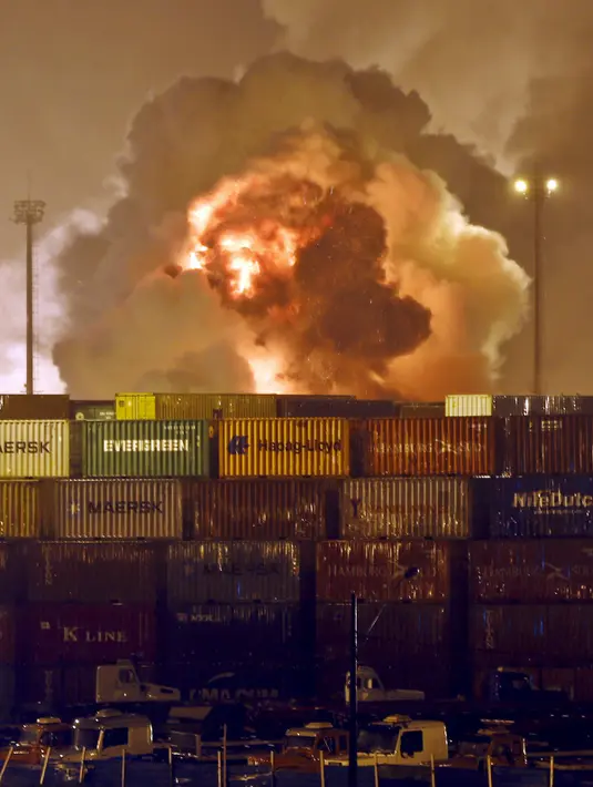 Api terlihat membakar wadah bahan kimia milik perusahaan logistik Localfrio di Guaruja, Brasil, Kamis (14/1). Perusahaan pemilik gudang tersebut menyatakan bahwa sejumlah kontainer penuh asam klorida dan zat suci hama. (REUTERS/Paulo Whitaker)