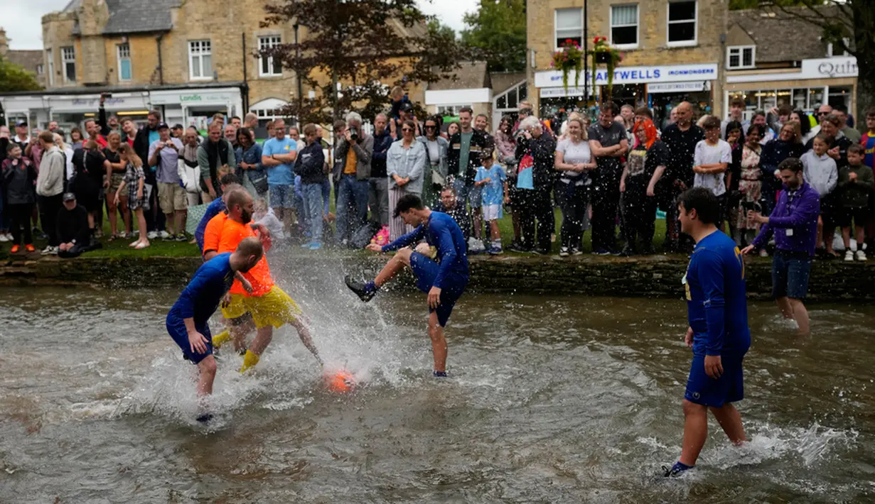 <p>Acara ini menampilkan dua tim beranggotakan enam orang dari Bourton Rovers Football Club memainkan pertandingan sepak bola selama 30 menit di air sungai yang dangkal. (AP Photo/Frank Augstein)</p>
