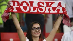 Suporter wanita tersenyum sambil membentangkan syal sebelum pertandingan grup H Piala Dunia 2018 antara Polandia melawan Senegal di Stadion Spartak di Moskow, Rusia (19/6). Dalam pertandingan ini Polandia takluk atas Senegal 2-1. (AFP Photo/Franck Fife)