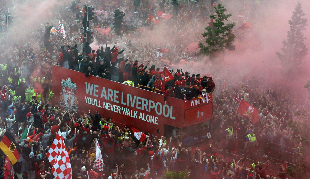 Ribuan fans Liverpool memadati jalan-jalan kota untuk menyambut tim kebanggaan mereka yang melakukan parade di atas bus terbuka pada Minggu (29/05/2022) waktu setempat. Musim ini, The Reds berhasil meraih dua trofi yaitu Piala FA dan Piala Liga Inggris. (AFP/Nigel Roddis)