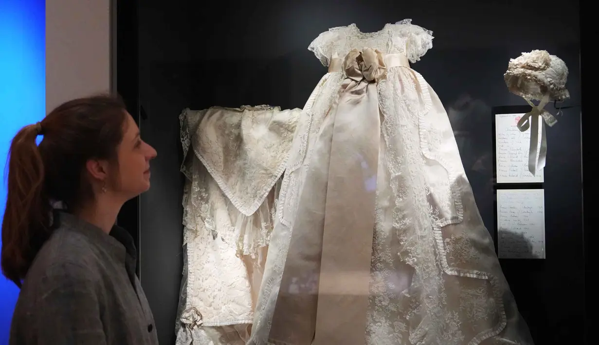 Busana ini merupakan pilihan pribadi mendiang Ratu Elizabeth II, mulai dari masa kecil hingga saat pemerintahannya. Tampak dalam foto, Cecilia Oliver, Konservator Tekstil di Royal Collection Trust, melihat ke arah Jubah Pembaptisan Kerajaan dari tahun 1841 yang dikenakan oleh Putri Elizabeth yang dipamerkan di pameran 'Queen Elizabeth II: Her Life in Style', di The King's Gallery, Istana Buckingham, London, Inggris, Kamis 9 April 2026. (AP Photo/Kirsty Wigglesworth)