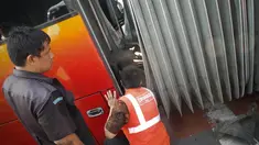 Petugas sedang memperbaiki sambungan bus gandeng transjakarta yang terbelah di kawasan Jatinegara, Jakarta, Kamis (7/8/14). (Liputan6.com/Faizal Fanani)