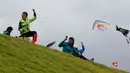 Orang-orang menerbangkan layang-layang selama festival musim panas di taman Simon Bolivar, Bogota, 12 Agustus 2018. Layang-layang beraneka warna dan bentuk menghiasi ibu kota Kolombia tersebut. (AFP PHOTO/John VIZCAINO)