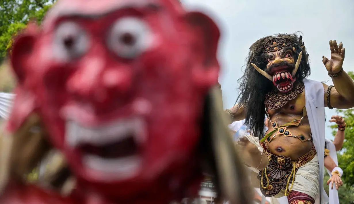 Ogoh-ogoh menjadi ikon ritual utama dalam menyambut Hari Raya Nyepi, khususnya pada hari Pangrupukan (sehari sebelum Nyepi). Tampak dalam foto, para penganut Hindu membawa Ogoh-ogoh, patung yang melambangkan roh jahat, selama pawai menjelang Nyepi di Surabaya pada Rabu 18 Maret 2026. (JUNI KRISWANTO/AFP)