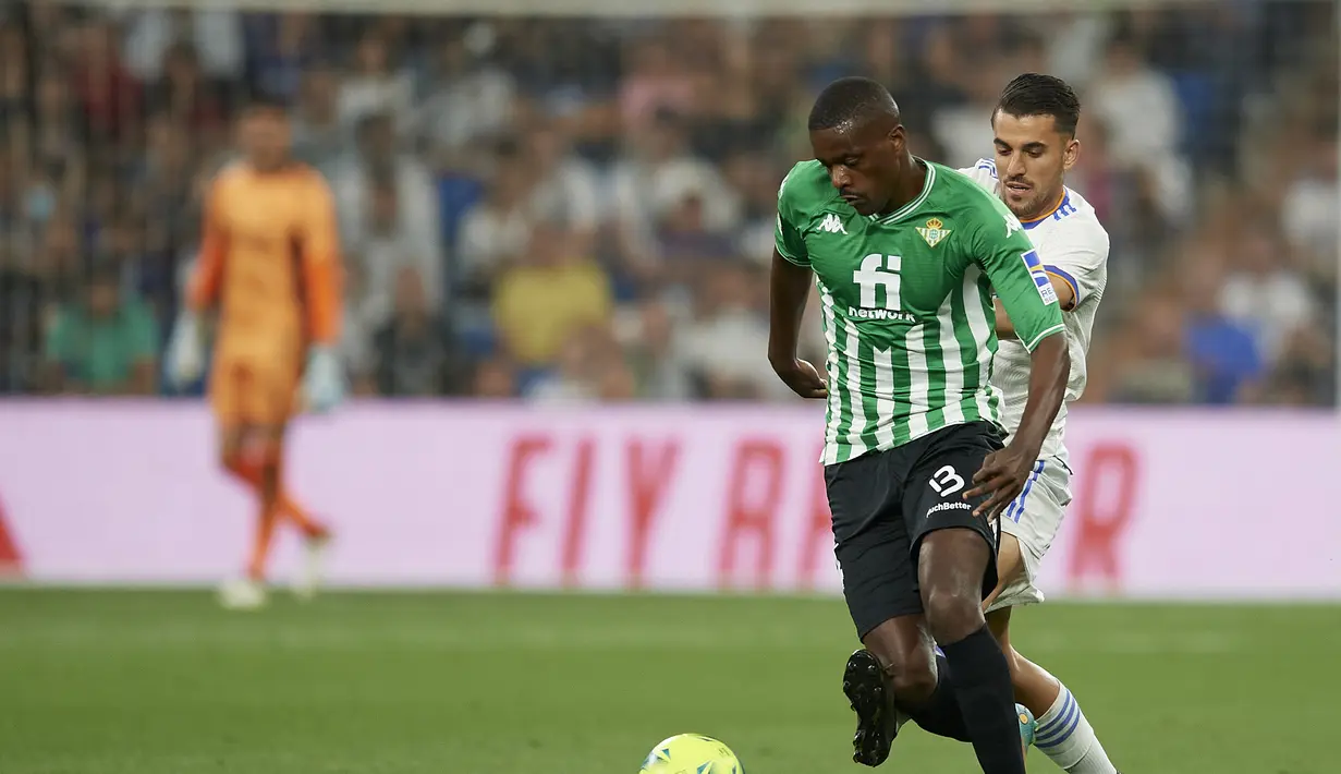 Gelandang Real Betis, William Carvalho berebut bola dengan gelandang Real Madrid, Dani Ceballos pada pertandingan laga terakhir La Liga Spanyol di stadion Santiago Bernabeu di Madrid, Spanyol, Sabtu (21/5/2022). Real Madrid menutup laga La Liga Spanyol musim ini dengan hasil imbang 0-0 melawan Real Betis. (AP Photo/Jose Breton)
