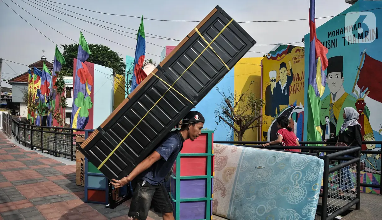 Warga mengangkut barang saat mulai menghuni di Kampung Gembira Gembrong, Cipinang Besar Utara, Jakarta Timur, Minggu (9/10/2022). Pasca diresmikan oleh Gubernur DKI Jakarta pada Jumat (7/10) kemarin, warga korban kebakaran yang sebelumnya mengungsi di Rusun Cipinamg Besar Utara kini mulai kembali menghuni Kampung Gembira Gembrong. (merdeka.com/Iqbal S. Nugroho)