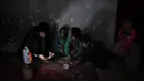 Bocah penjual air, Afghan Zilgai (9), bersama ayah dan saudaranya menghitung penghasilannya di rumahnya di Kabul, 20 Februari 2016. Afghan setiap hari menjual air kepada para peziarah dengan penghasilan 1,5 USD/hari. (AFP PHOTO/Wakil KOHSAR)