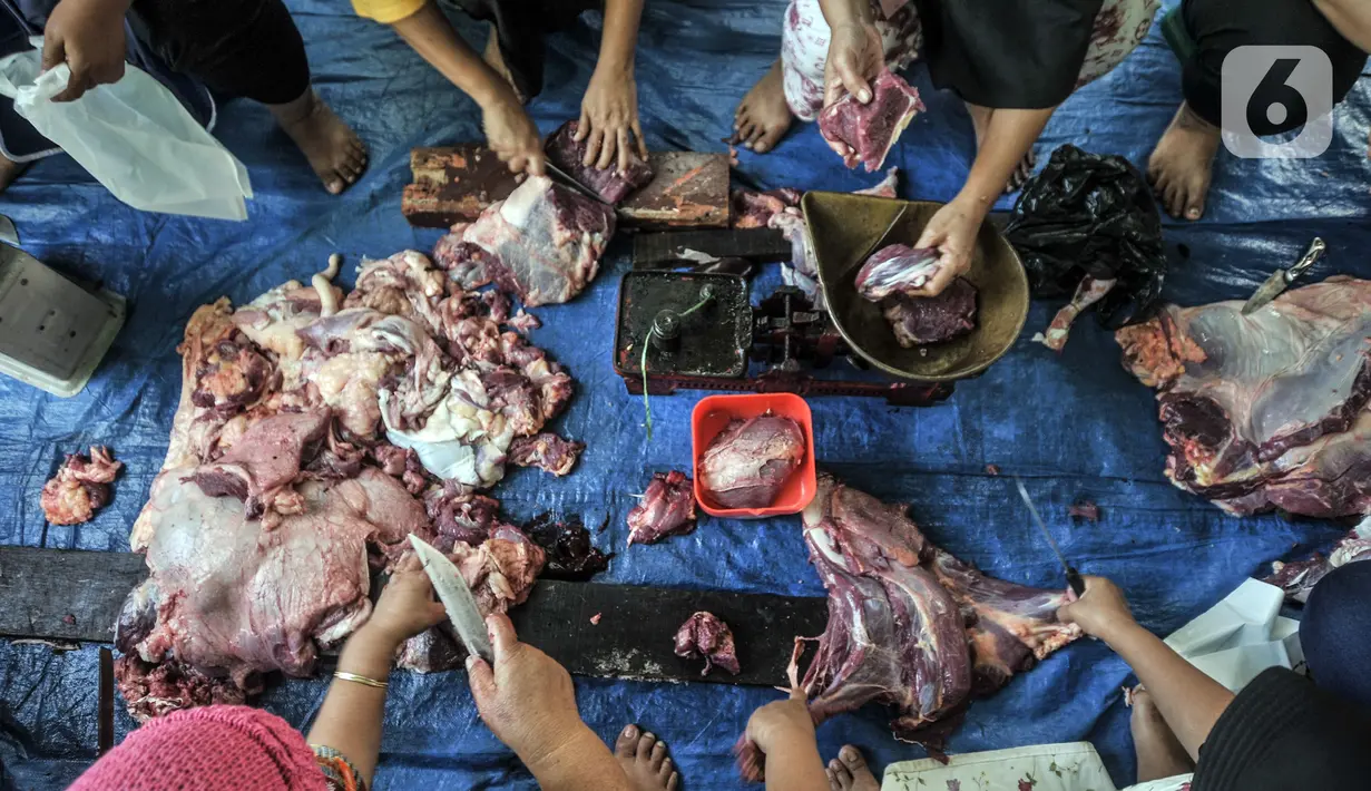Panitia memotong daging hewan kurban saat perayaan Hari Raya Idul Adha 1442 H di Musala Nurul Huda, Jakarta, Selasa (20/7/2021). Panitia diwajibkan mengenakan masker dan menerapkan protokol kesehatan guna mencegah penyebaran COVID-19. (merdeka.com/Iqbal S. Nugroho)