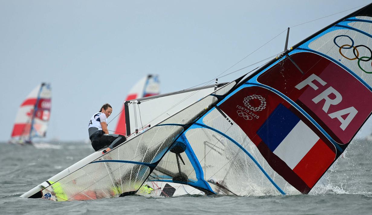Atlet layar asal Prancis Lili Sebesi dan Albane Dubois menyelamatkan diri diatas perahu layar yang terbalik saat lomba skiff 49er FX 2 layar putri Olimpiade Tokyo 2020 di Enoshima Yacht Harbor di Fujisawa, Jepang, pada 27 Juli 2021. (Foto: AFP/Peter Parks)