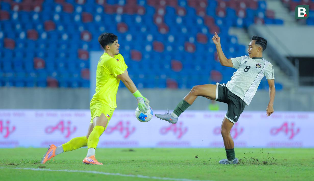 Pemain Timnas Indonesia U-22, Rayhan Hannan, berebut bola dengan kiper Filipina U-22, Nicholas Guimaraes pada laga Grup C SEA Games 2025 di 700th Anniversary Stadium, Senin (8/12/2025). (Bola.com/Bagaskara Lazuardi)