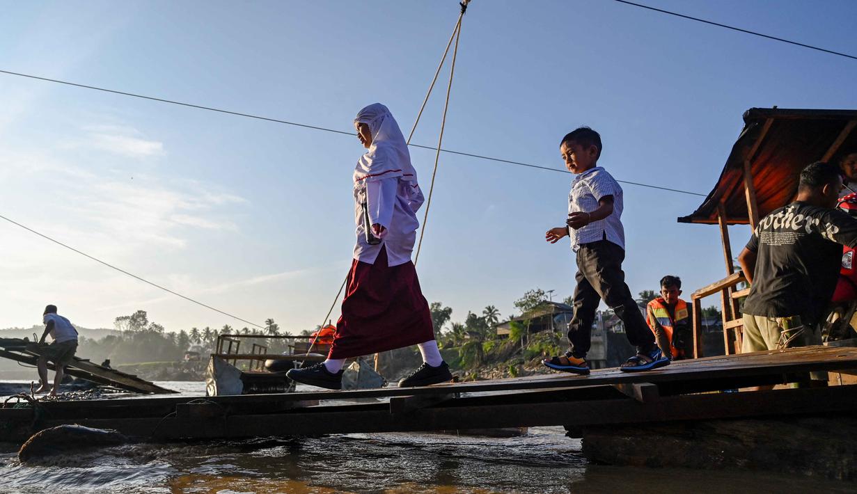 Sejumlah siswa menaiki perahu darurat untuk menyeberangi Sungai Peusangan pasca banjir bandang yang menghancurkan desa-desa di sekitarnya di kabupaten Bireuen, provinsi Aceh, Indonesia pada Senin 5 Januari 2026. Secara resmi, Dinas Pendidikan dan Kebudayaan (Disdikbud) Bireuen telah menetapkan jadwal masuk sekolah usai libur semester pada Senin (5/1/2025). (CHAIDEER MAHYUDDIN/AFP)
