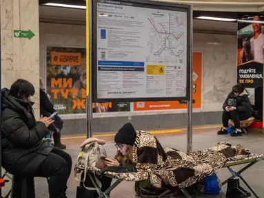 Warga berlindung di stasiun metro selama serangan pesawat tak berawak dan rudal Rusia di Kyiv, Ukraina, pada 9 Januari 2026 pagi hari waktu setempat, di tengah invasi Rusia ke Ukraina. Stasiun metro bawah tanah di Kyiv menjadi solusi utama para warga setempat untuk berlindung dari serangan drone dan rudal Rusia. (Serhii Okunev/AFP)