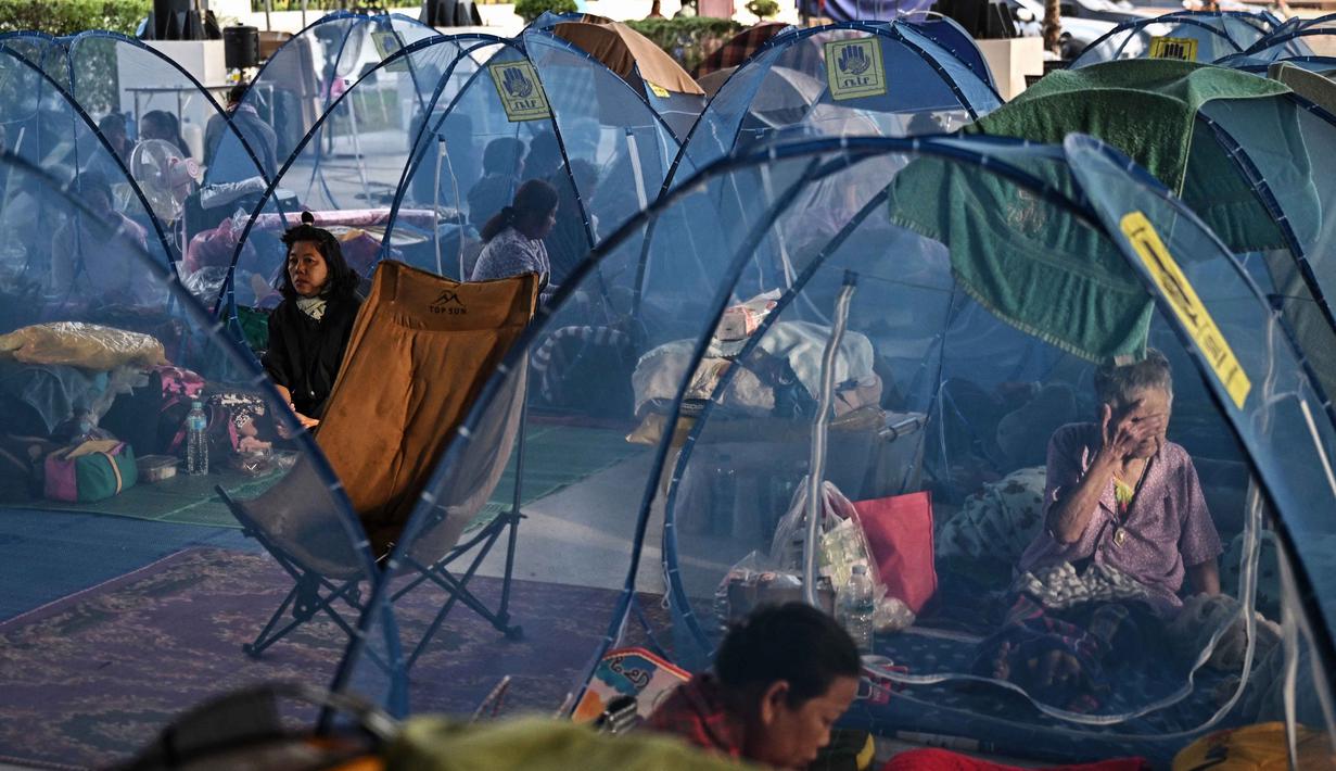 Penting diketahui, negara bertetangga ini berselisih mengenai demarkasi perbatasan sepanjang 800 kilometer yang berasal dari era kolonial Prancis. Tampak dalam foto, warga pengungsi beristirahat sambil berlindung di pusat pengungsian selama bentrokan di sepanjang perbatasan Thailand-Kamboja di Provinsi Sa Kaeo, Thailand, pada Rabu 10 Desember 2025. (Lillian SUWANRUMPHA/AFP)