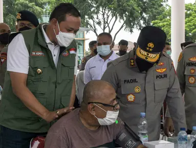 Kapolda Metro Jaya Irjen Pol Fadil Imran (kanan) dan Plt Wali Kota Bekasi Tri Andhianto (kiri) berbincang dengan warga lansia yang mengikuti vaksinasi di Alun-Alun Bekasi, Jawa Barat, Rabu (23/2/2022). Sebanyak 600 dosis vaksin Sinovac disiapkan dalam vaksinasi ini. (Liputan6.com/Herman Zakharia)