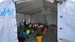 Beberapa guru Palestina memberikan pendidikan dasar di sekolah darurat yang didirikan oleh Asosiasi Kebudayaan Mayasem dengan dukungan UNICEF di kamp pengungsian di kawasan al-Qarara, Khan Yunis, di bagian selatan Jalur Gaza pada Selasa 7 Oktober 2025. (Omar AL-QATTAA/AFP)