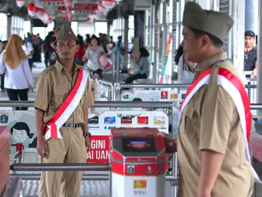 Petugas Trans Jakarta mengenakan pakaian tentara perjuangan tempo dulu di Halte Trans Jakarta, Selasa (16/8). Memperingati HUT RI Ke-71, koridor Trans Jakarta dihiasi nuansa kemerdekaan. (Liputan6.com/Angga Yuniar)